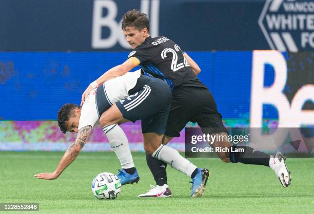 Jukka Raitala of the Montreal Impact and Fredy Montero of the Vancouver Whitecaps battle for the ball during MLS soccer action at BC Place on...