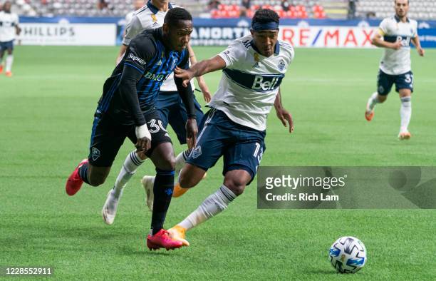 Derek Cornelius of the Vancouver Whitecaps and Romell Quioto of the Montreal Impact chase after a loose ball during MLS soccer action at BC Place on...