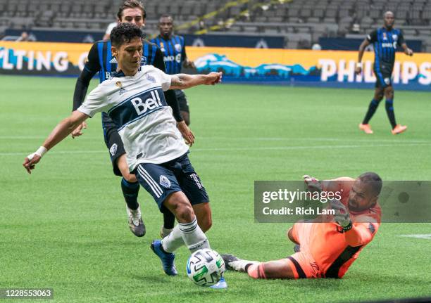 Fredy Montero of the Vancouver Whitecaps tries to gain control of the ball while goalkeeper Clement Diop of the Montreal Impact challenges on the...