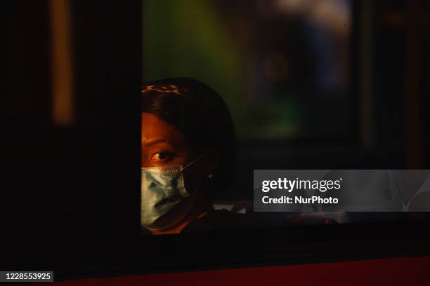 Woman wearing a face mask looks out from a bus on Oxford Street in London, England, on September 16, 2020. While the UK continues to edge towards...