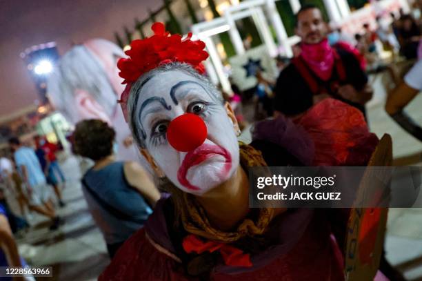 An Israeli woman wearing a clown outfit takes part in a demonstration against the government and an imminent and unprecedented second nationwide...