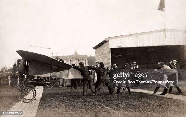 Vintage postcard featuring a monoplane being prepared for take-off during an aviation meeting at Groningen airfield in the Netherlands, circa August...