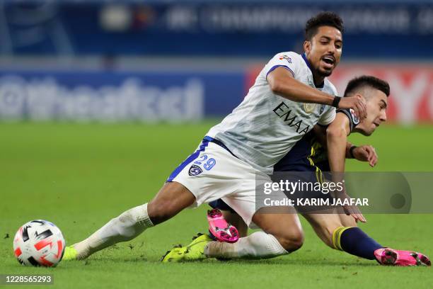 Hilal's midfielder Salem al-Dawsari vies for the ball against Pakhtakor's defender Akramjon Komilov during the AFC Champions League group B match...