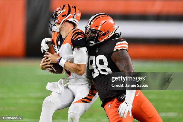 Sheldon Richardson of the Cleveland Browns wraps up quarterback Joe Burrow of the Cincinnati Bengals for a sack in the first quarter at FirstEnergy...