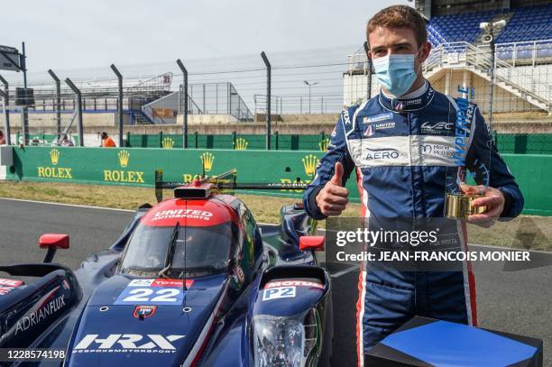 British's driver Paul Di Resta poses by his Oreca 07-Gibson LMP2 WEC racing car after he clocked the LMP2 Category best time during the 88th edition...