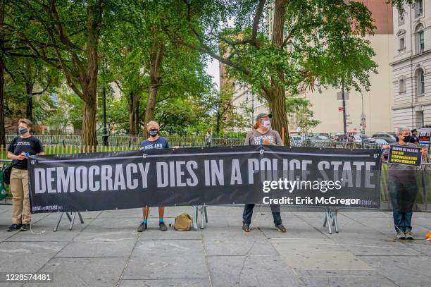 Participants holding a banner reading "Democracy Dies In A Police State". Members of the activist group Rise and Resist gathered on the east side of...