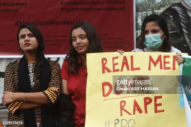 Demonstrator holds a placard next to others during a protest against an alleged gang rape of a woman, in Karachi on September 18, 2020. - Hundreds of...