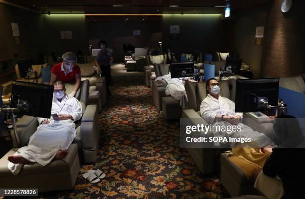 Staff member wearing a face mask is seen massaging a man at a beauty spa. Government officials said that they should further relax social-distancing...