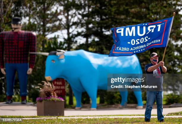 Jerry Hemstad waves a flag in support of President Donald Trump near the statues of Paul Bunyan and Babe the Blue Ox on September 18, 2020 in...