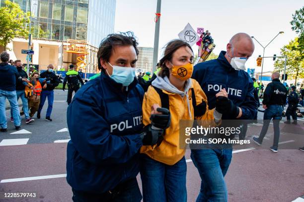 Female climate activist being arrested by the Dutch police during the demonstration. Prior to the blockade, climate activists gathered at the Gustav...