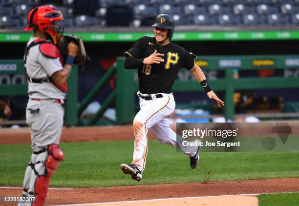 John Ryan Murphy of the Pittsburgh Pirates scores in front of Yadier Molina of the St. Louis Cardinals during the fourth inning of game one of a...