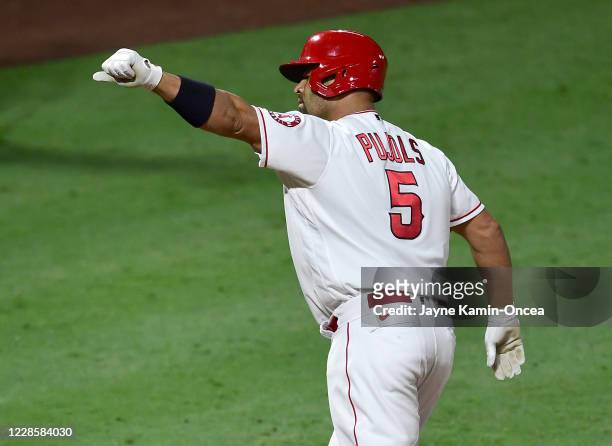 Albert Pujols of the Los Angeles Angels crosses the plate after hitting career home run No. 661 passing Hall of Famer and San Francisco Giants legend...