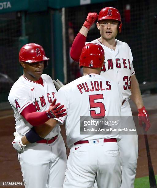 Albert Pujols is congratulated by Justin Upton and Max Stassi of the Los Angeles Angels after hitting career home run No. 661 passing Hall of Famer...