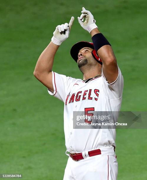 Albert Pujols of the Los Angeles Angels points to the sky as he crosses the plate after hitting home run, his second on the night, in the seventh...