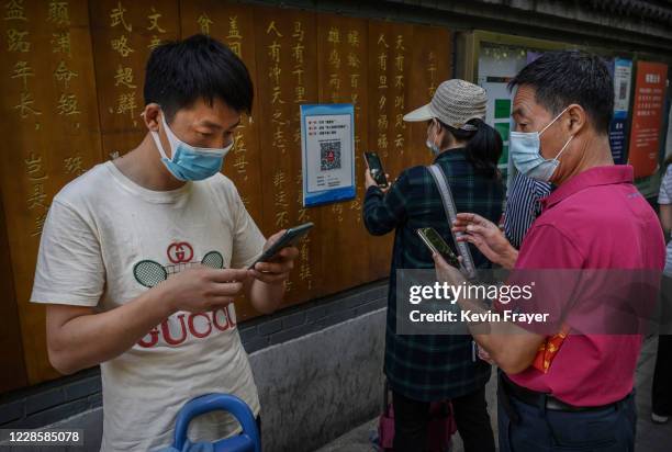Chinese customers use the WeChat app to scan a health code before entering a local market on September 19, 2020 in Beijing, China. The Trump...