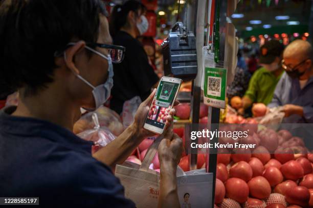 Chinese customer uses his mobile to pay via a QR code with the WeChat app at a local market on September 19, 2020 in Beijing, China. The Trump...