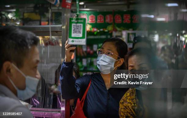 Chinese customer uses her mobile to scan a QR code while paying with the WeChat app at a local market on September 19, 2020 in Beijing, China. The...