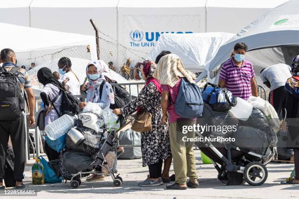 Thousands of asylum seekers are seen in queues waiting to register and enter the new temporary refugee camp in Lesbos island in Greece after the fire...