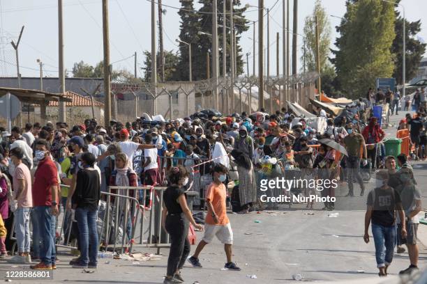 Thousands of asylum seekers are seen in queues waiting to register and enter the new temporary refugee camp in Lesbos island in Greece after the fire...