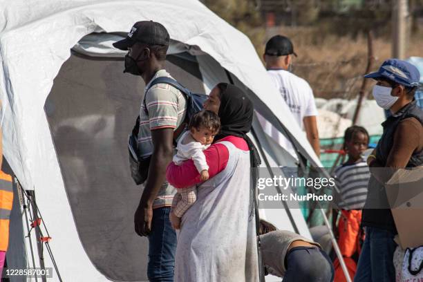 Thousands of asylum seekers are seen in queues waiting to register and enter the new temporary refugee camp in Lesbos island in Greece after the fire...