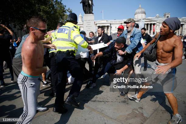 Protestors clash with Met Police officers during an Anti-Vax rally at Trafalgar Sq on September 19, 2020 in London, England.