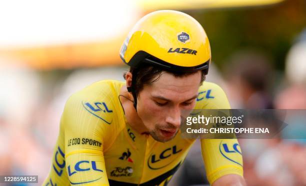 Team Jumbo rider Slovenia's Primoz Roglic wearing the overall leader's yellow jersey crosses the finish line at the end of the 20th stage of the...