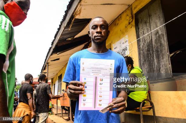 Man has his ballot paper displayed before casting his vote, during the governorship election in Benin City, Edo State. As voters gathered to polls in...