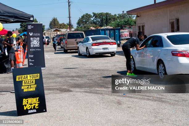 Volunteer helps people to register to vote at the Gen-Z Drive Up Voter Registration Event organized by BeWoke Vote, September 19 in Compton,...