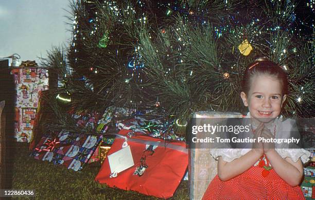 girl siting in front of christmas tree - vintage christmas stock-fotos und bilder