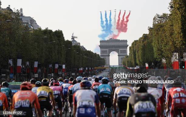 French air force's aerobatics demonstration unit "Patrouille de France" performs as the pack rides on the Champs Elysees avenue with the Arc de...