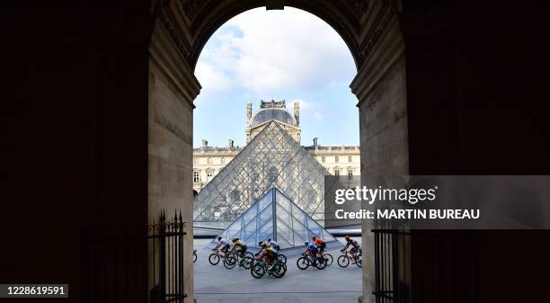 The pack rides in front of the Louvre pyramid and museum during the 21st and last stage of the 107th edition of the Tour de France cycling race, 122...