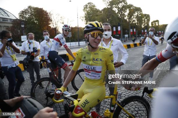 Team UAE Emirates rider Slovenia's Tadej Pogacar wearing the overall leader's yellow jersey celebrates after winning the 107th edition of the Tour de...