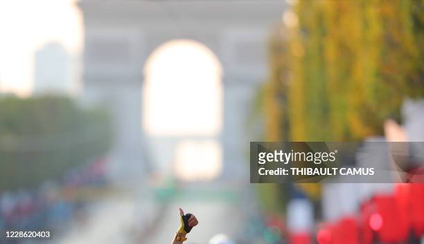 Team UAE Emirates rider Slovenia's Tadej Pogacar wearing the overall leader's yellow jersey celebrates after winning the 107th edition of the Tour de...