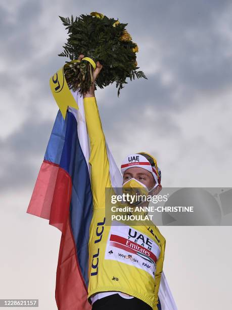 Team UAE Emirates rider Slovenia's Tadej Pogacar wearing the overall leader's yellow jersey celebrates on the podium after winning the 107th edition...