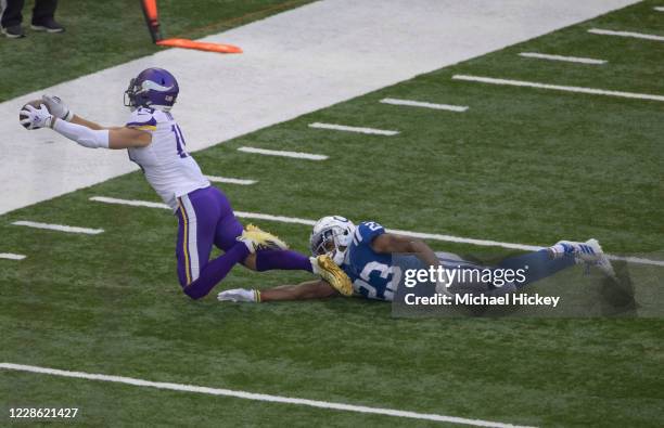 Adam Thielen of the Minnesota Vikings reaches for a pass as Kenny Moore II of the Indianapolis Colts defends during the first half at Lucas Oil...