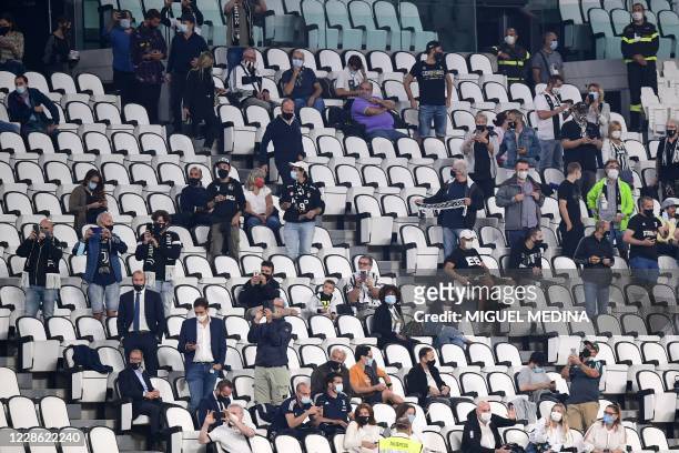 Socially distanced spectators sit in a tribune prior to the Italian Serie A football match Juventus vs Sampdoria on September 20, 2020 at the...