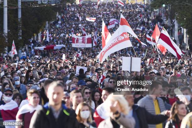 Belarusian opposition supporters carry Belarusian flags, which was used before 1995, as they take part in a rally against presidential election...