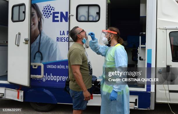 Journalist is tested for COVID-19 at a mobile testing lab outside the Sanchez Pizjuan stadium in Seville, on September 21 as a requirement to attend...