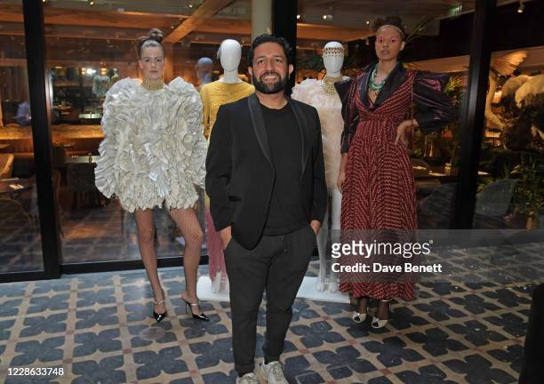 Osman Yousefzada poses with modesl at the OSMAN presentation during London Fashion Week September 2020 at The Mandrake Hotel on September 21, 2020 in...