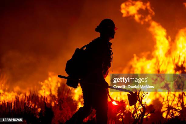 Firefighters battle the Bobcat Fire as it surpasses 100,000 acres on the evening of September 20, 2020 near Wrightwood, California. The fire has...