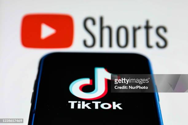 TikTok logo is seen displayed on a phone screen with YouTube Shorts logo in the background in this illustration photo taken on September 22, 2020 in...