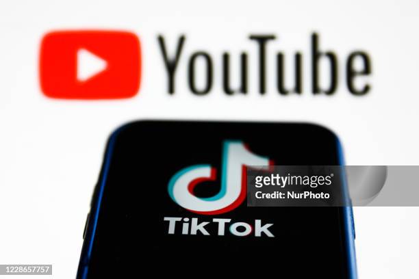 TikTok logo is seen displayed on a phone screen with YouTube logo in the background in this illustration photo taken on September 22, 2020 in Krakow,...