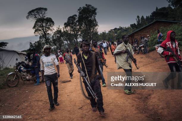 Militiamen, including alleged children, of the armed group URDPC/CODECO from the Lendu community stand guard during a meeting with former warlords -...