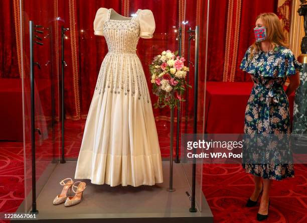 Princess Beatrice poses alongside her wedding dress as it goes on display at Windsor Castle on September 23, 2020 in Windsor, England. Princess...
