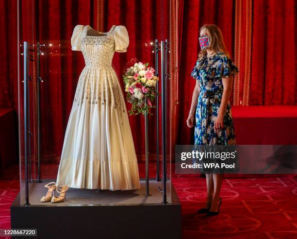 Princess Beatrice poses alongside her wedding dress as it goes on display at Windsor Castle on September 23, 2020 in Windsor, England. Princess...