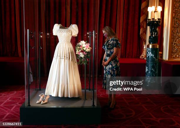 Princess Beatrice poses alongside her wedding dress as it goes on display at Windsor Castle on September 23, 2020 in Windsor, England. Princess...