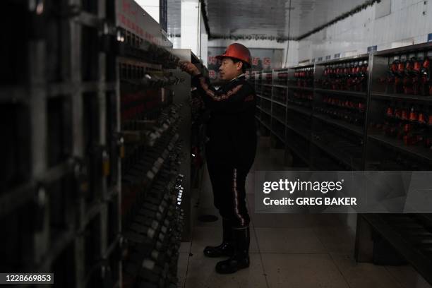 This photo taken on January 8, 2020 shows a worker putting away equipment after coming out of the Datai coal mine in Mentougou, west of Beijing. -...