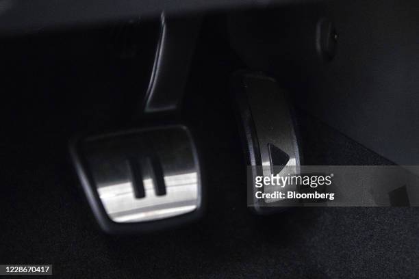 Pause and a play symbol sit on the brake and accelerator pedals of a Volkswagen AG ID.3 electric automobile at the Volkswagen AG electric vehicle...