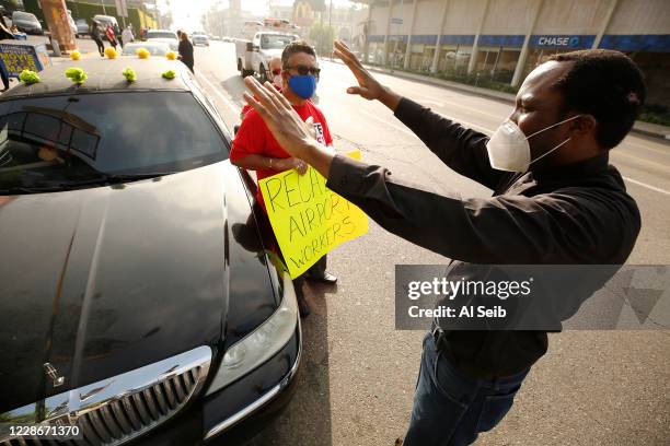 Father Ike Udoh, right, from the Church of the Blessed Sacrament in Hollywood along with diverse clergy blesses Frank Cueva, a supervisor and...