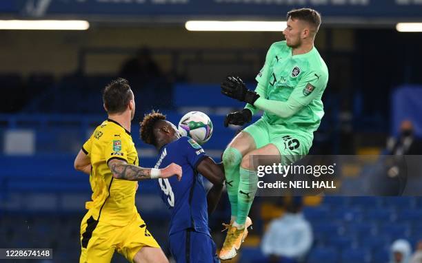 Chelsea's English striker Tammy Abraham and Barnsley's English goalkeeper Brad Collins go for the ball leading to a foul on Abraham during the...